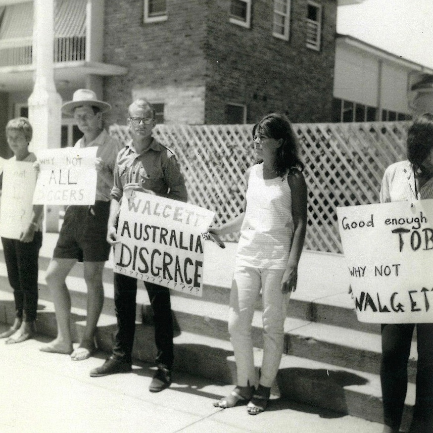 Group standing on street with protest signs