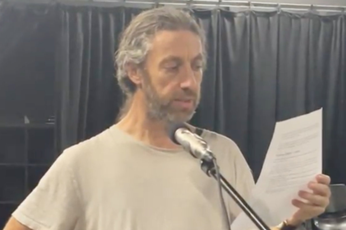 beardy man reading a script into a microphone