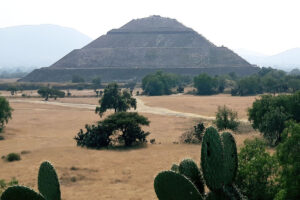 Photo of arid Mexican landscape with an ancient stone pyramid in the centre.